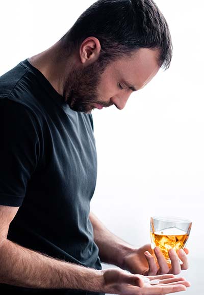 пьяный мужчина со стаканом алкоголя в руке