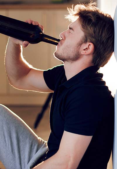 мужчина пьёт алкоголь из бутылки